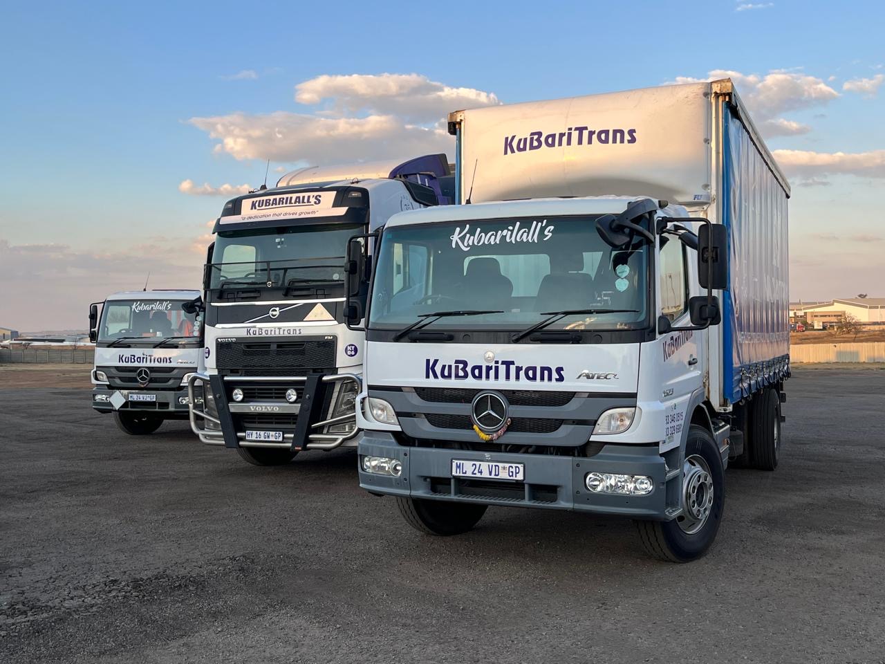 KuBariTrans fleet — Mercedes and Volvo trucks at dusk